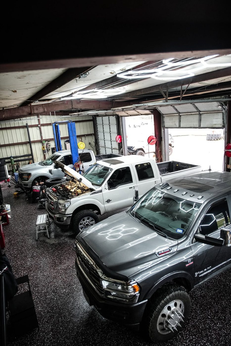 Inside the Unmatched Performance shop — trucks in the bays at 11850 FM 1960, Huffman TX